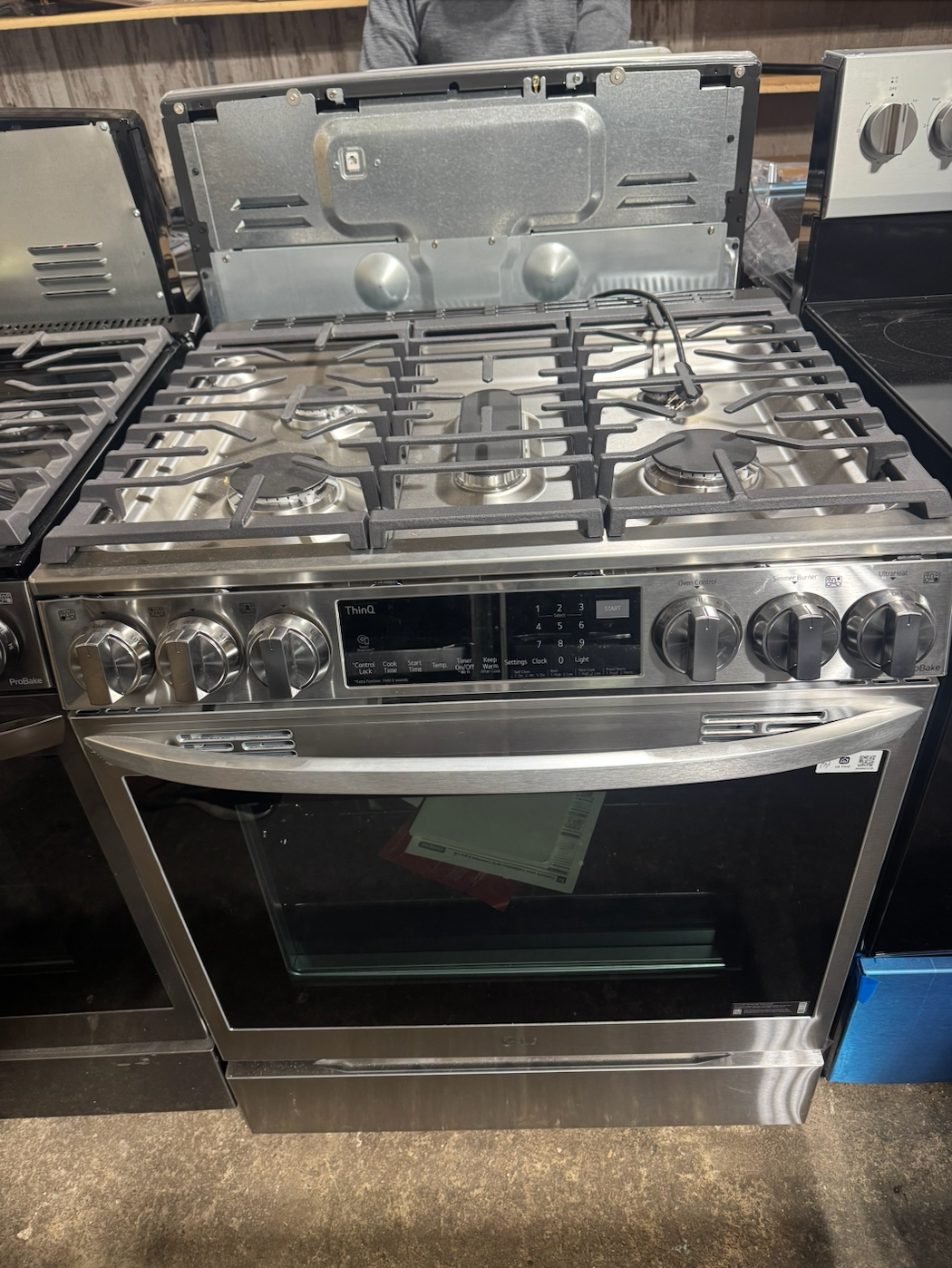 Stainless steel gas range with cooktop, oven, and control panel.
