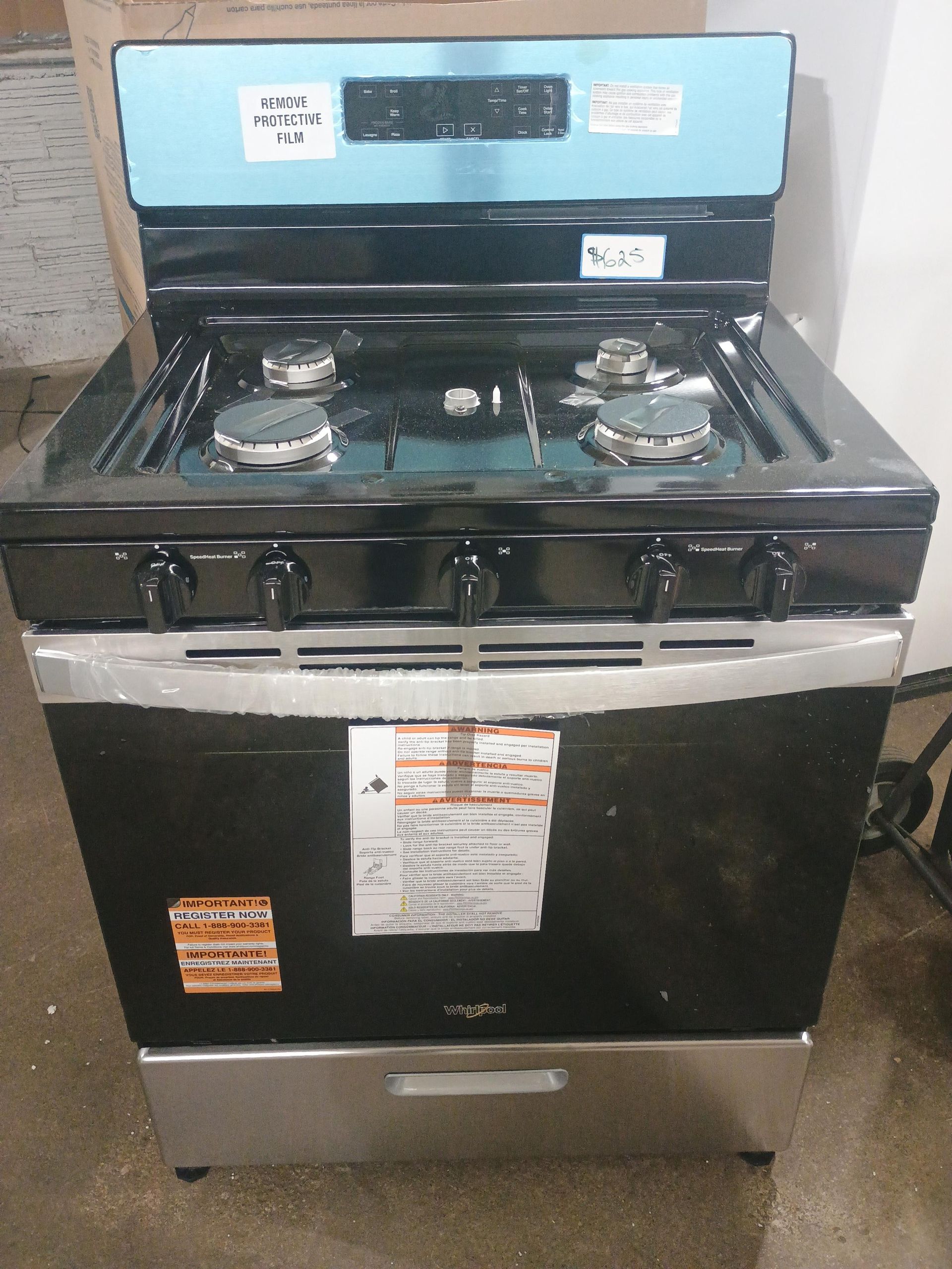 Black Whirlpool gas range with four burners, a blue backsplash, and a stainless steel drawer.
