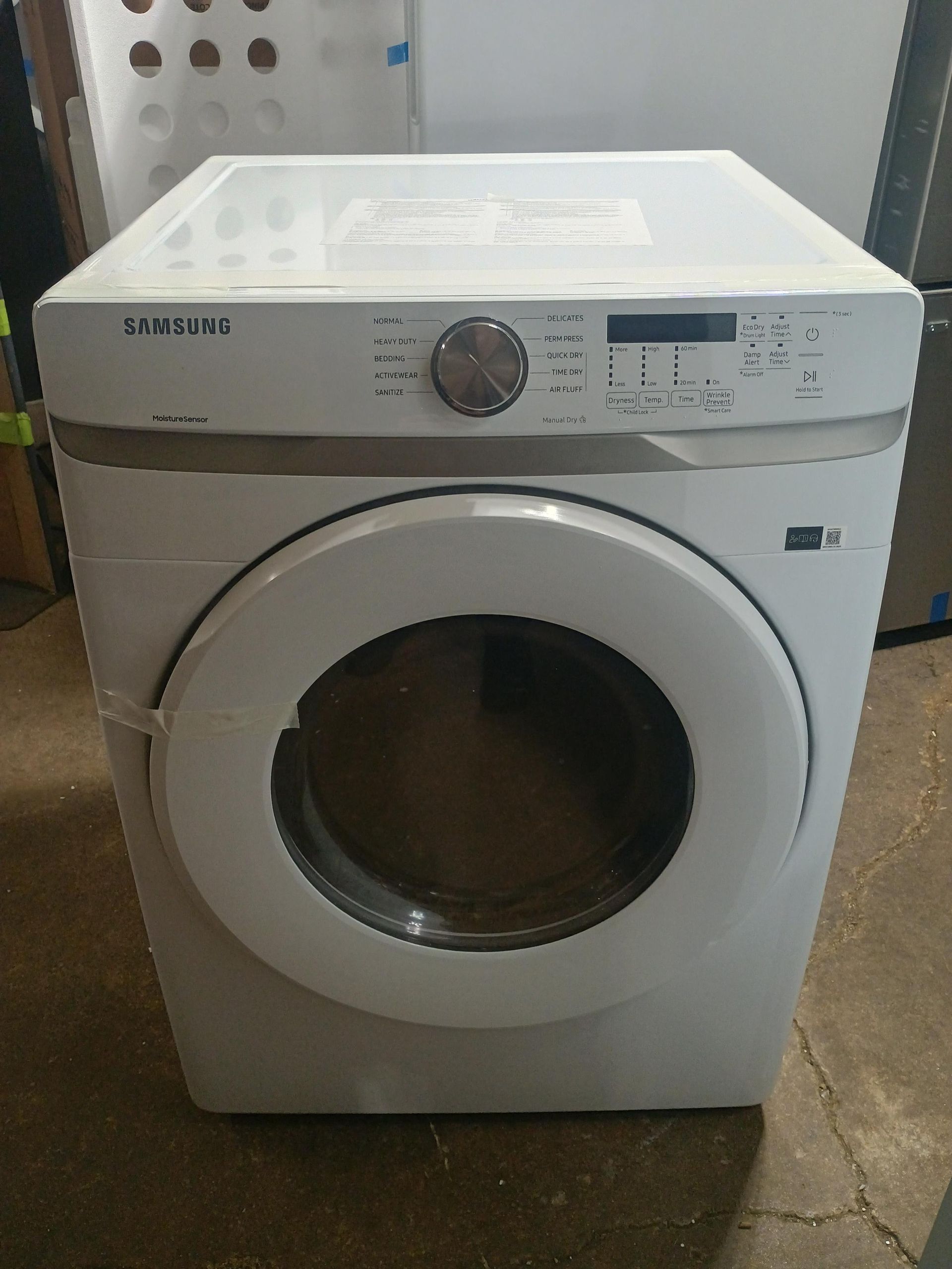 White Samsung clothes dryer with a round door, control panel, and silver dial.