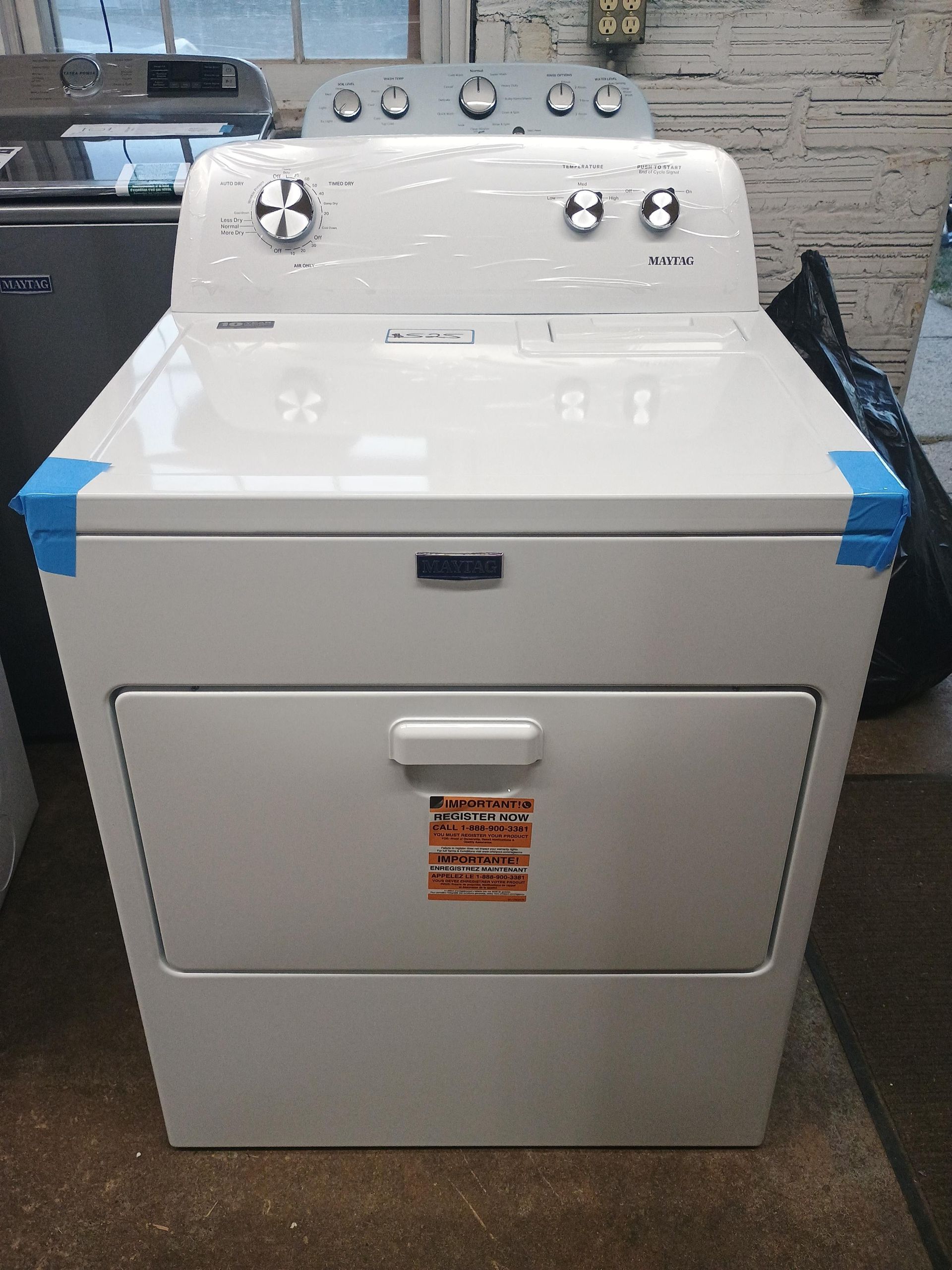 White Maytag dryer with control knobs and a lower door.