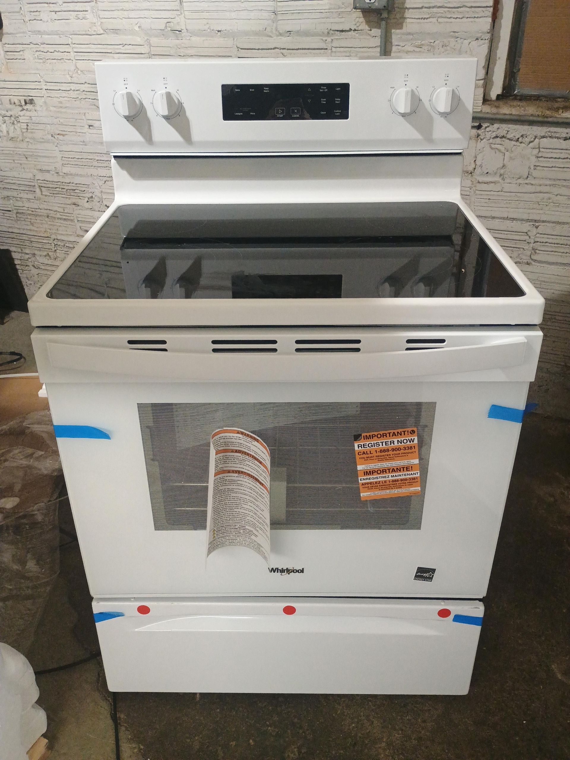 White Whirlpool electric range with glass cooktop and oven door.