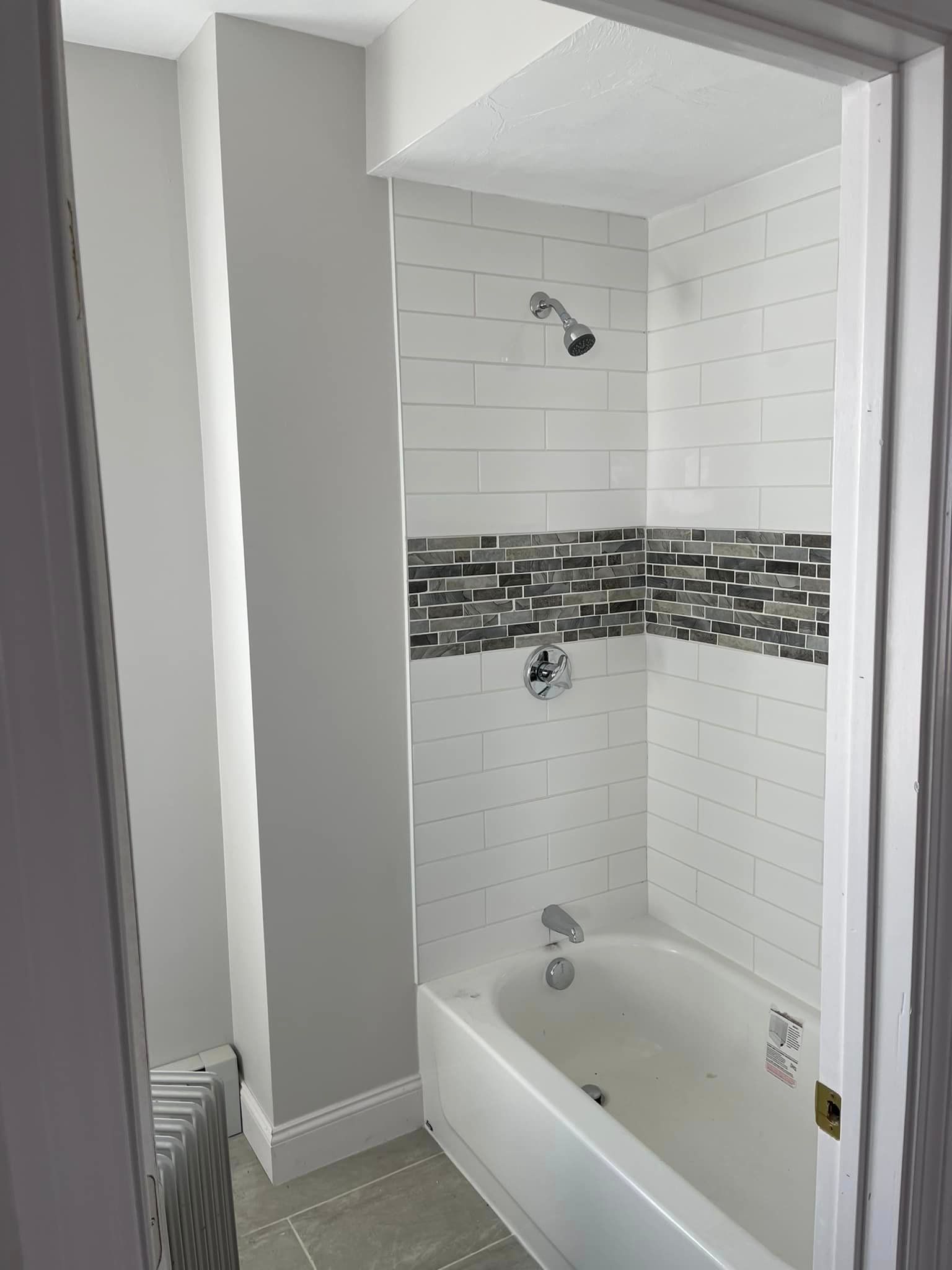 A bathroom with a bathtub and a shower.