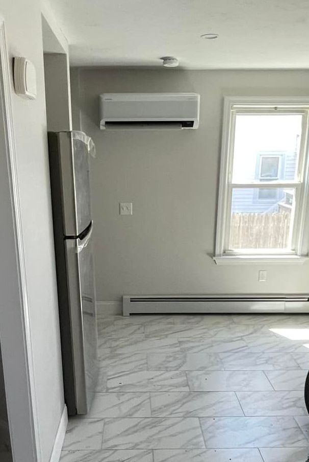 There is a refrigerator and a window in the room.