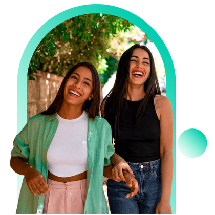 Dos mujeres están paradas una al lado de la otra y se ríen.