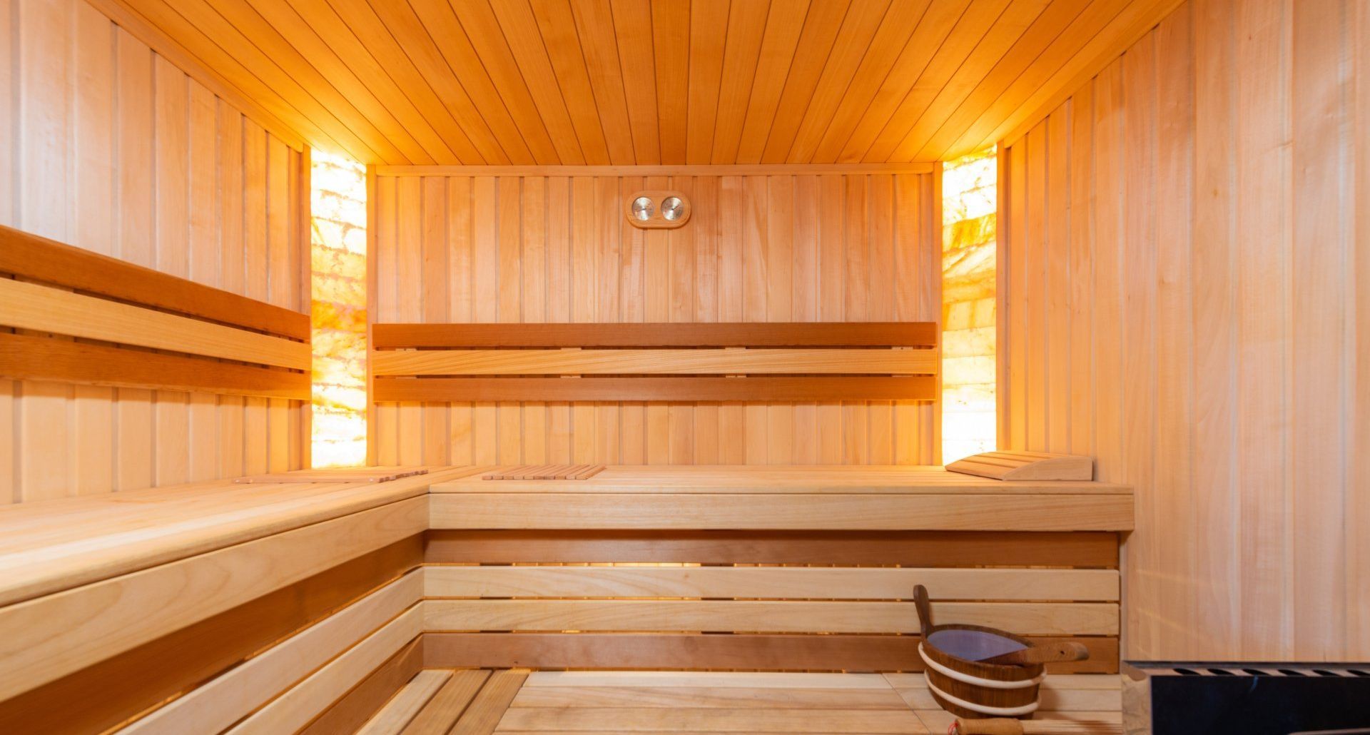 a wooden sauna with a bucket on the bench and sauna pillow