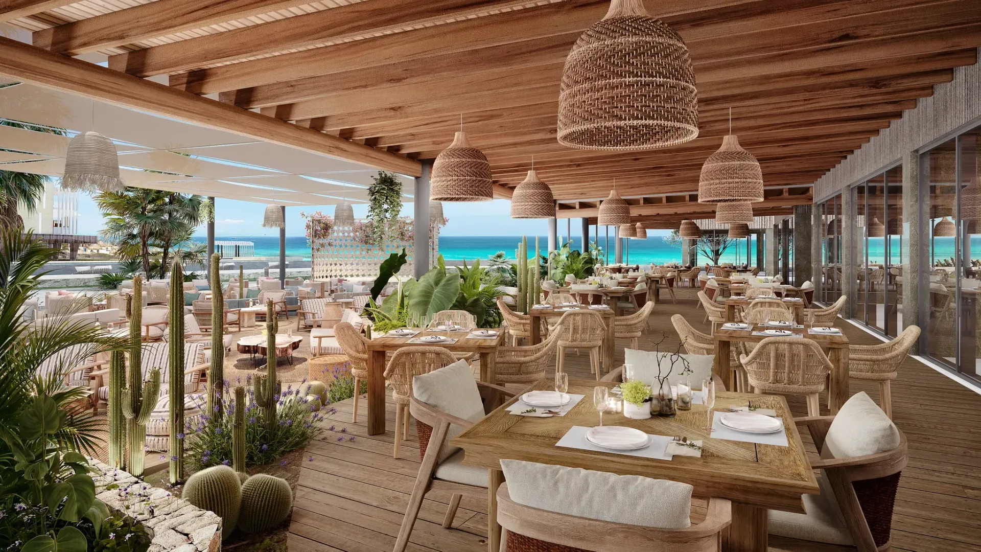 Restaurant patio overlooking a turquoise ocean. Wooden tables, woven chairs, and hanging wicker lamps.