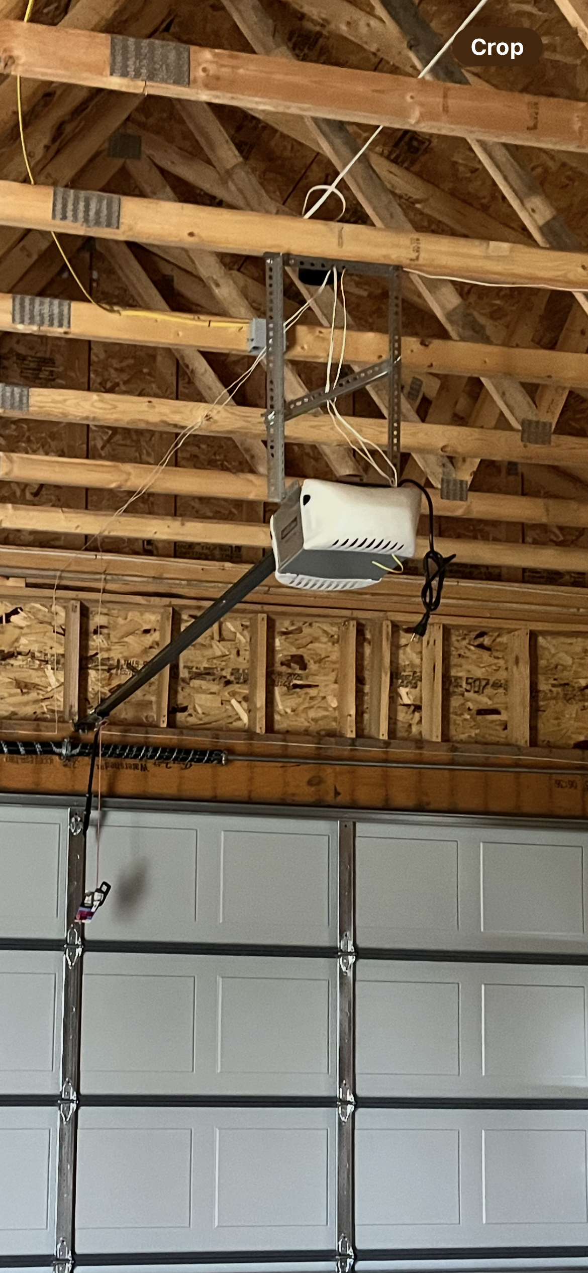 Garage door with opener mounted on the ceiling. The door is closed.