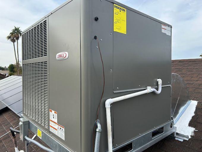 A large air conditioner is sitting on top of a roof.