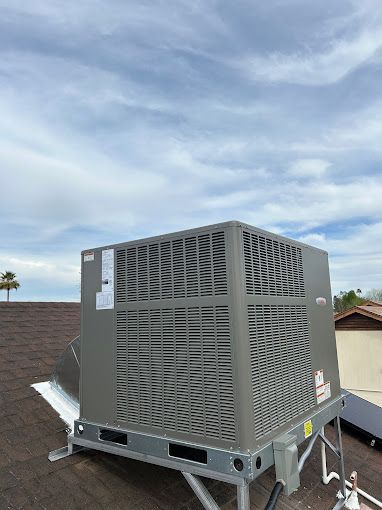 A large air conditioner is sitting on top of a roof.