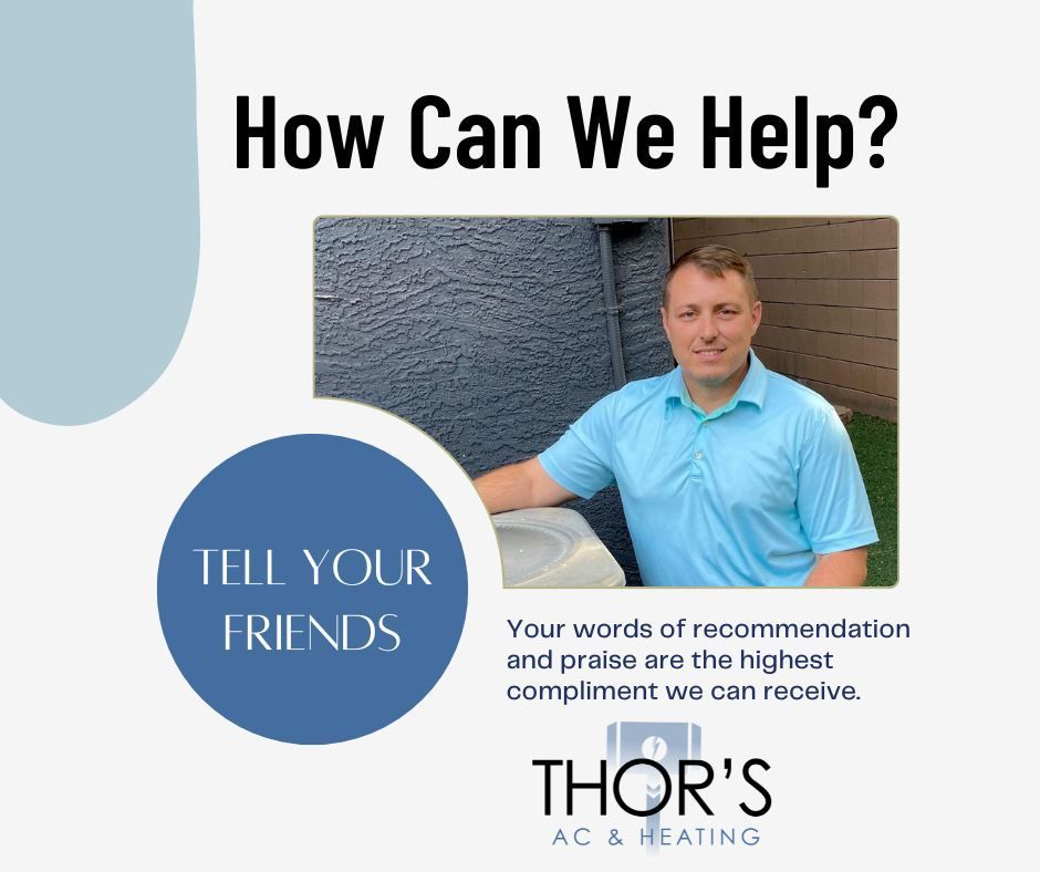 A man in a blue shirt is standing next to an air conditioner.