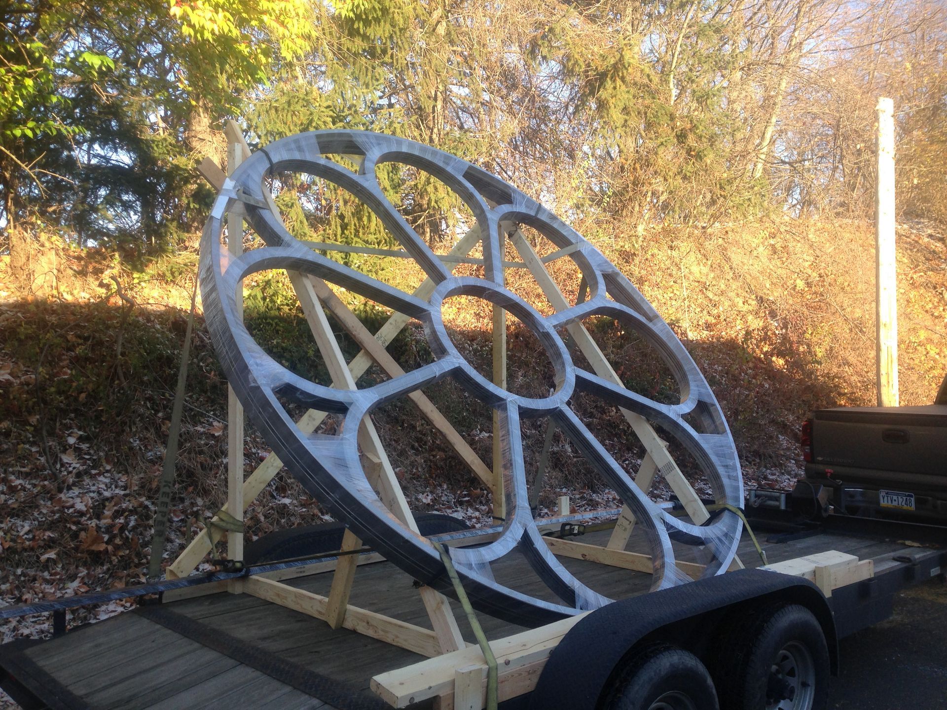 A large wheel is sitting on top of a trailer.