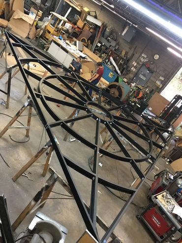 A large metal structure is being built in a workshop.