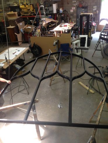 A large metal structure is being built in a workshop