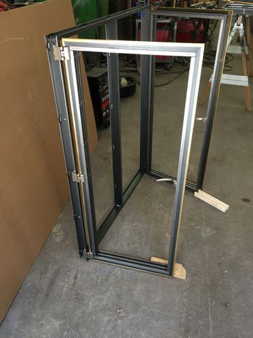 A door frame is sitting on the floor in a garage.