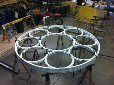 A round piece of metal is sitting on top of a wooden table.