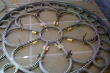 A wrought iron flower is sitting on a table.