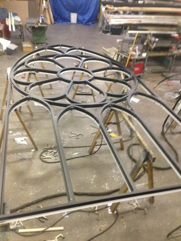 A metal structure is being built in a workshop.