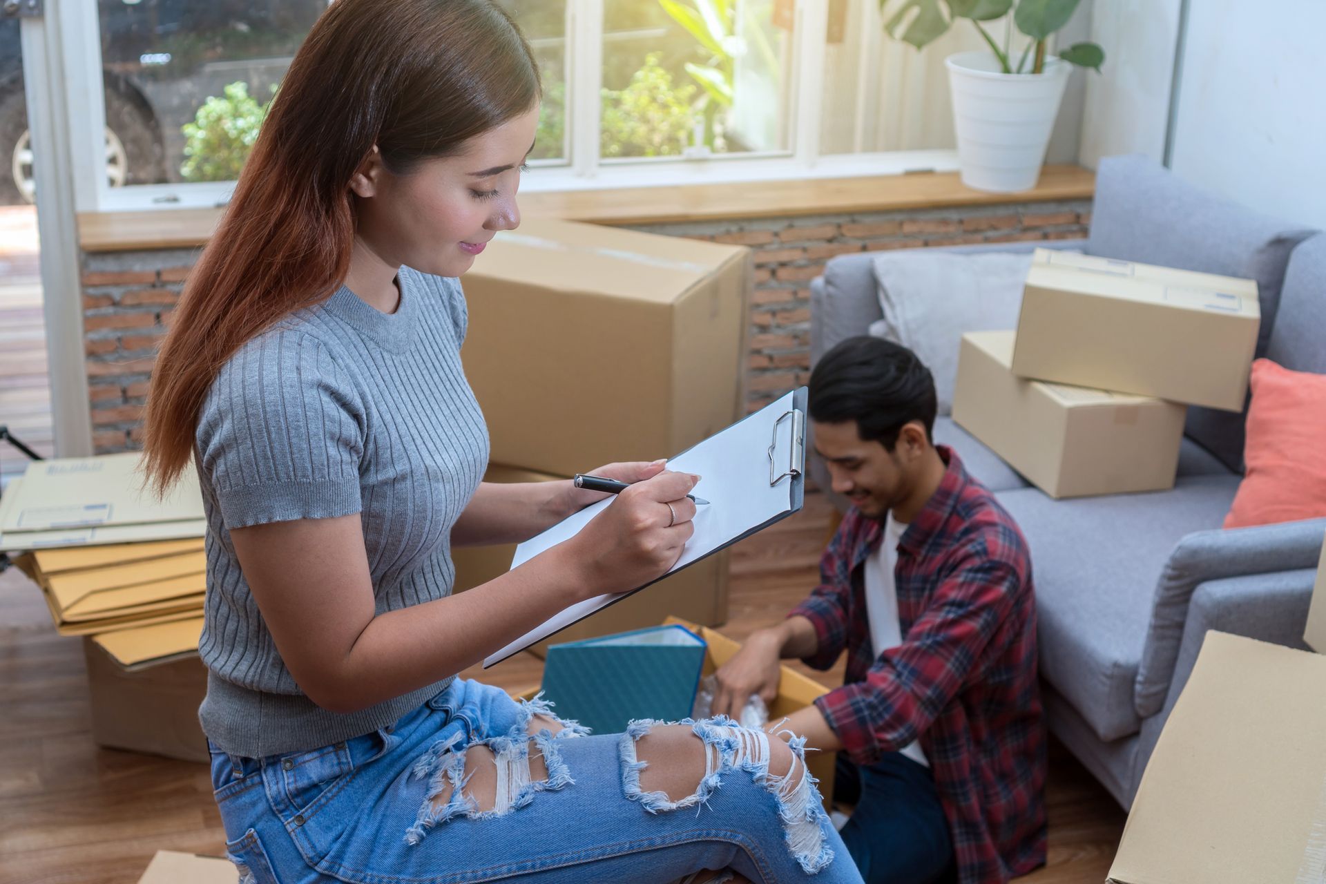 A woman is sitting on the floor next to a man in a living room.