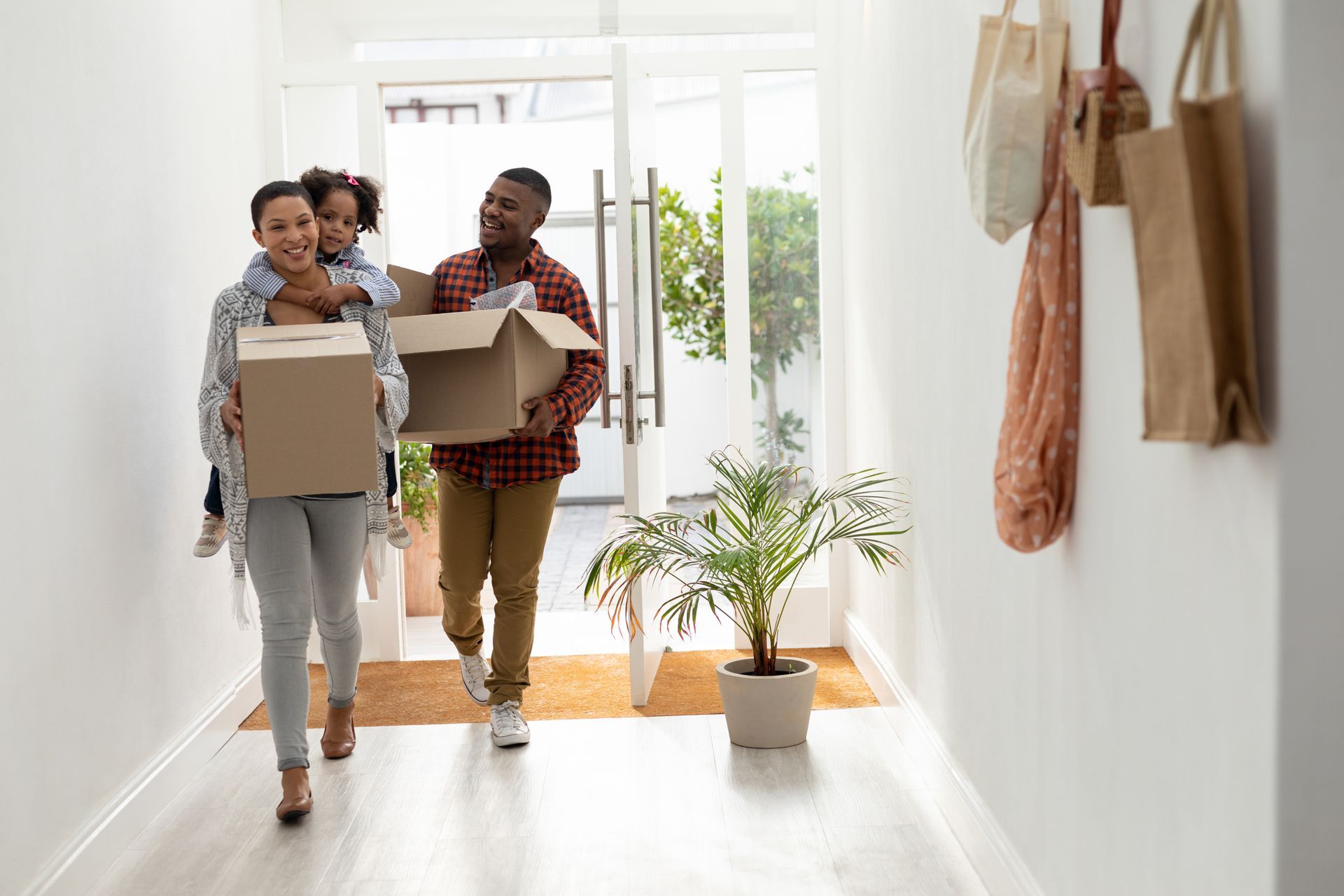 A family is carrying boxes into a new home.
