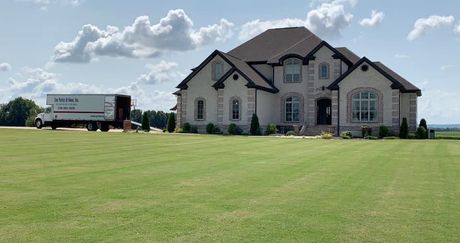 A large house with a moving truck parked in front of it.