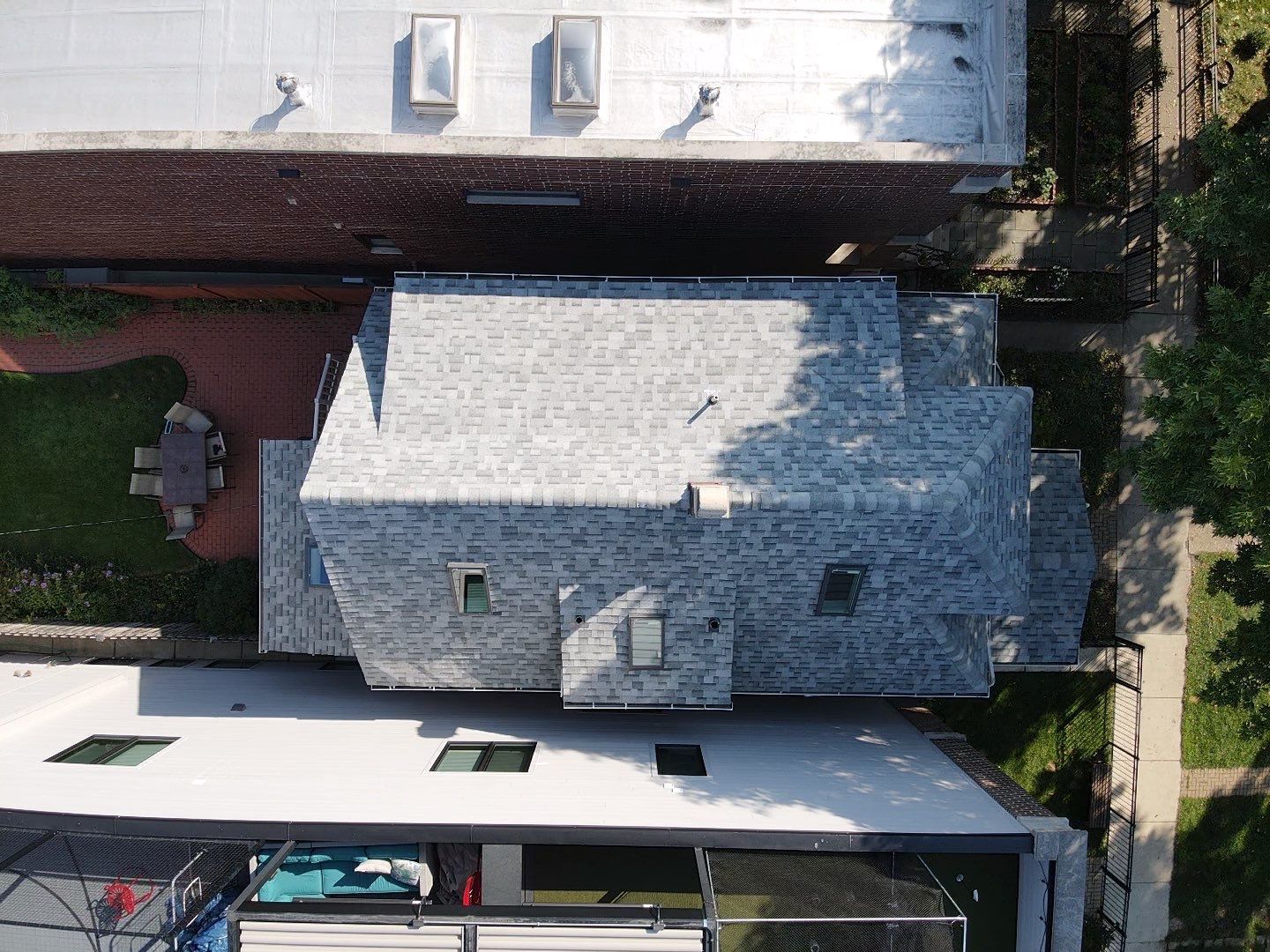 An aerial view of a house with a white roof