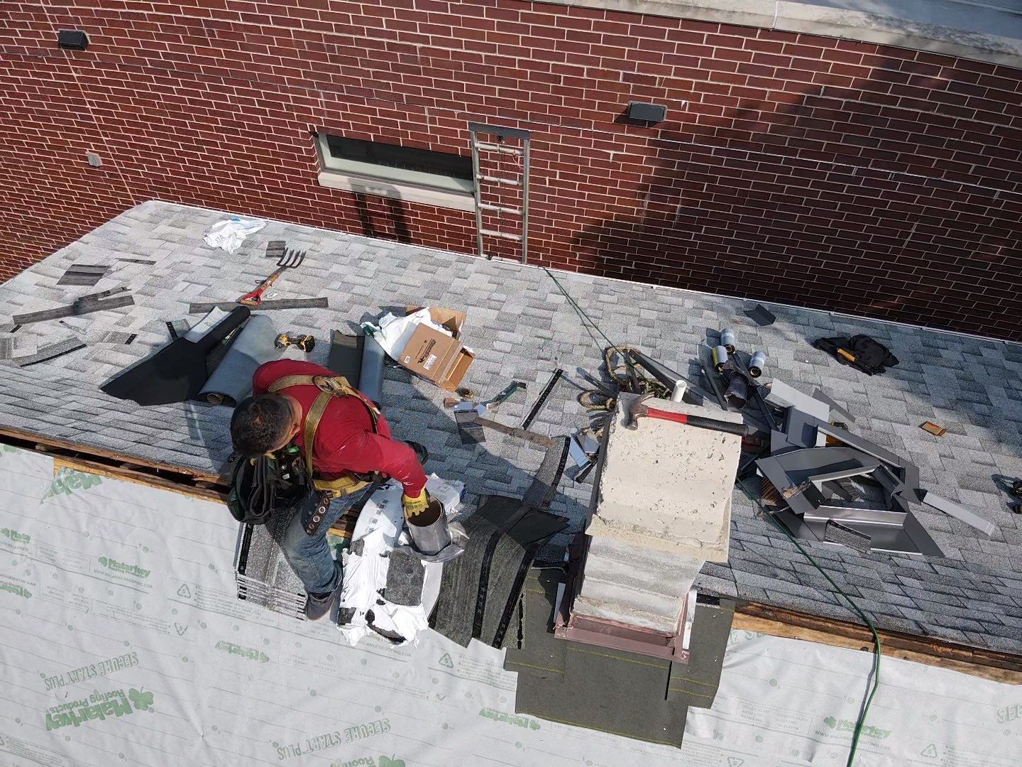 A man is working on the roof of a building.
