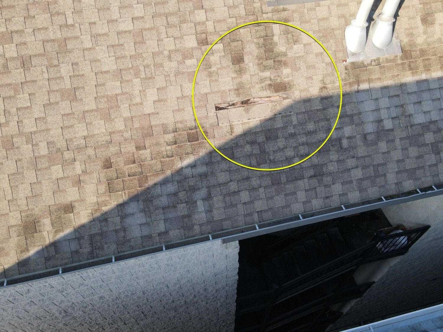 An aerial view of a roof with a yellow circle around it