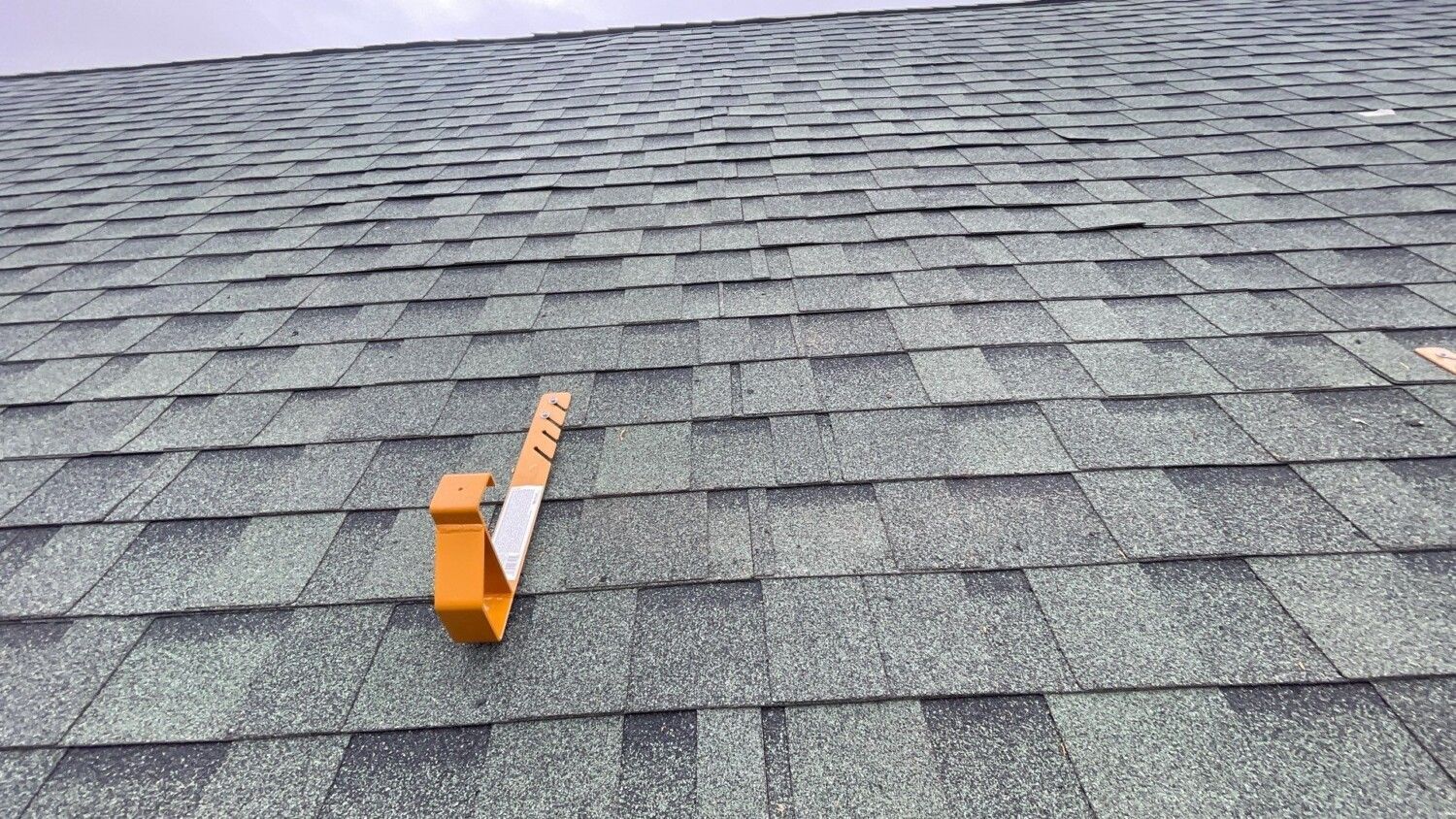 A tape measure is sitting on top of a roof.