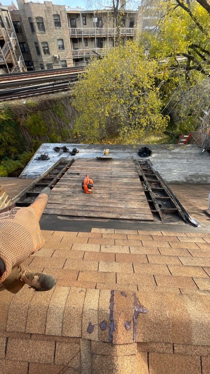 A person is working on a roof with a hammer.