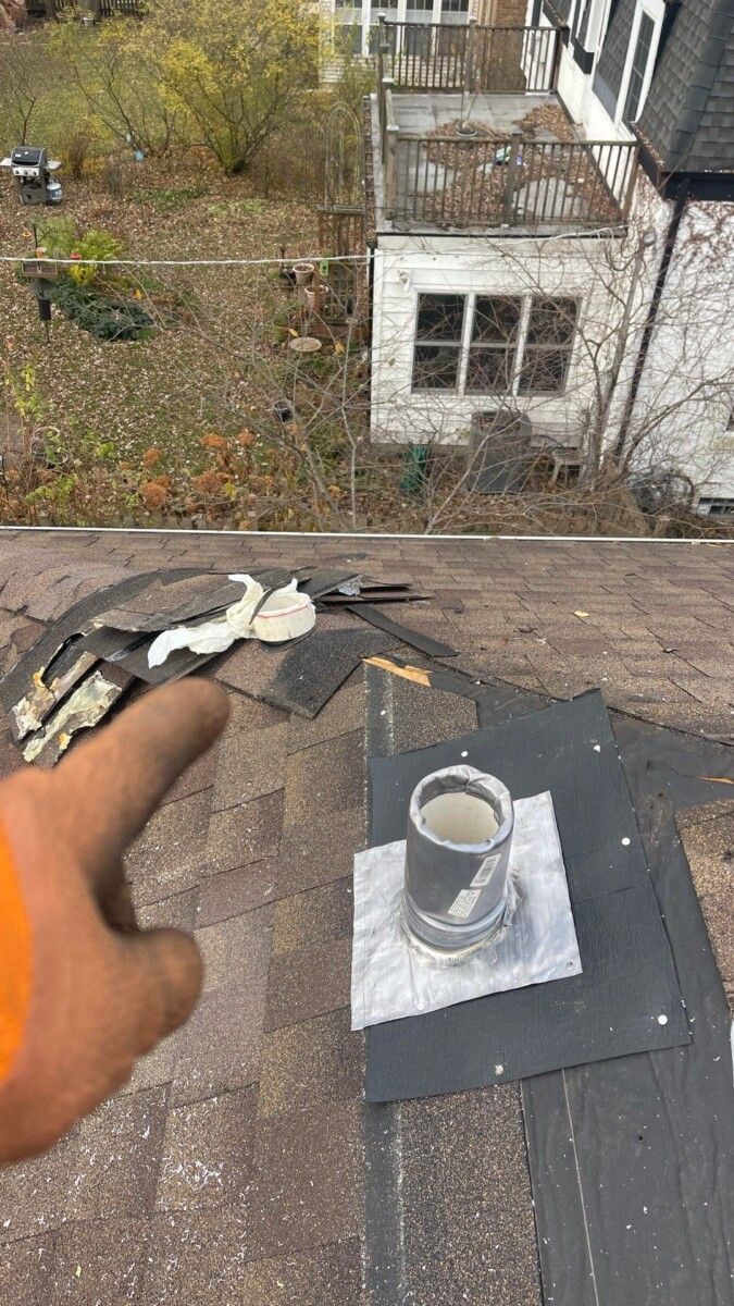 A person is holding a cup of coffee on top of a roof.
