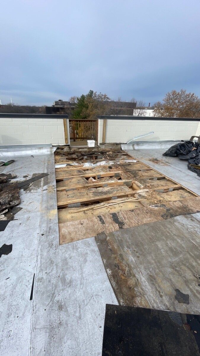 A roof with a lot of wood on it is being demolished.