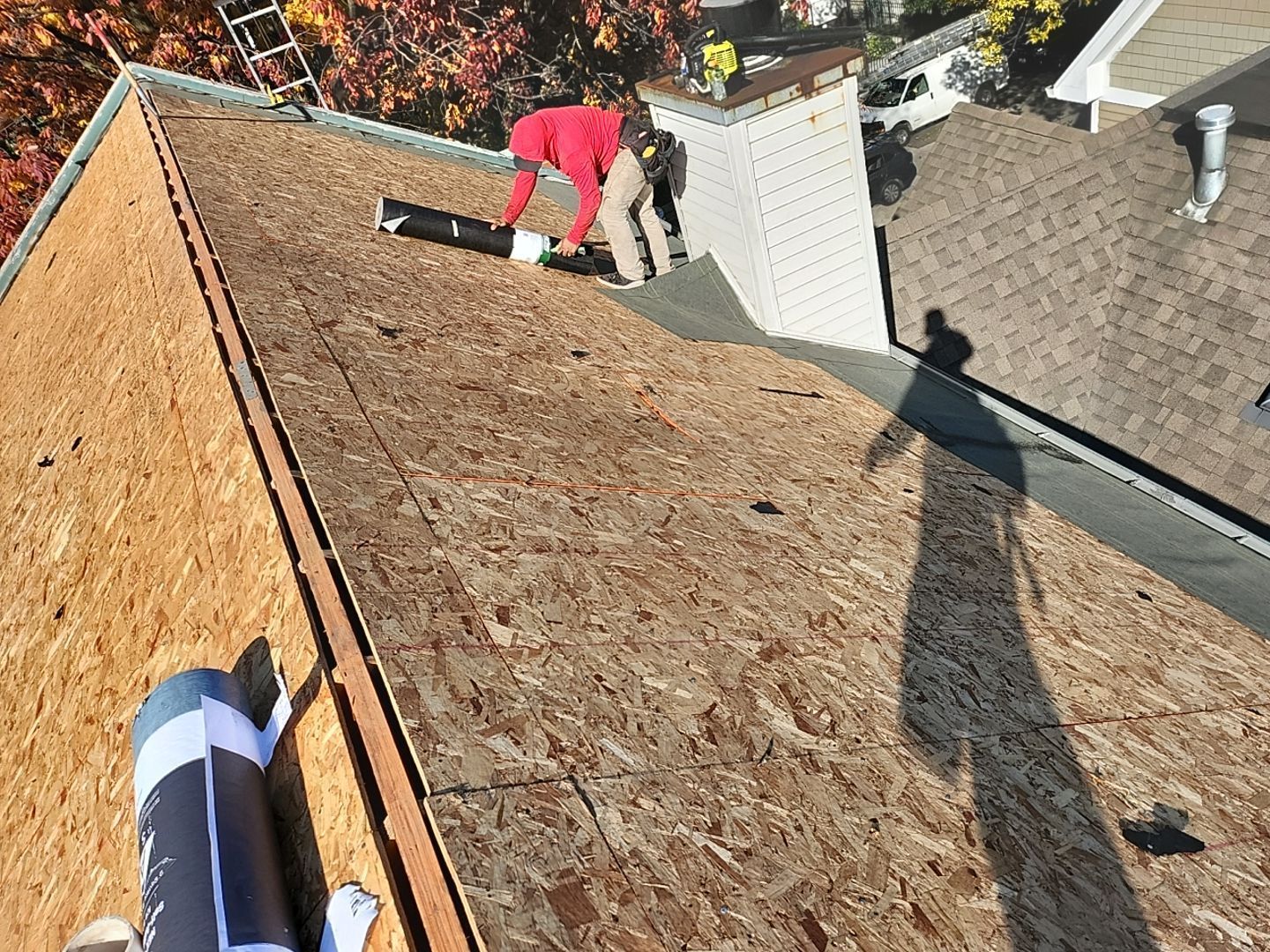 A man is working on the roof of a house.