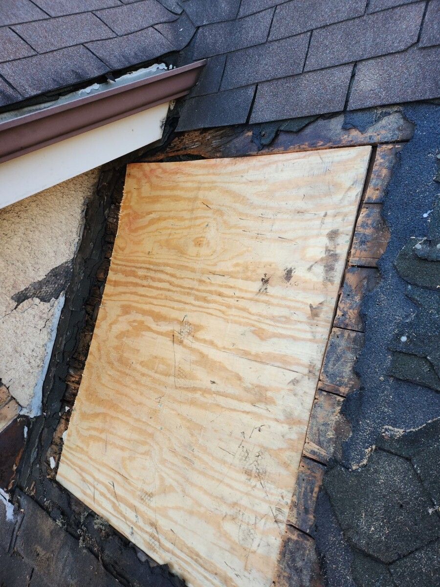 A piece of plywood is sitting on top of a roof.