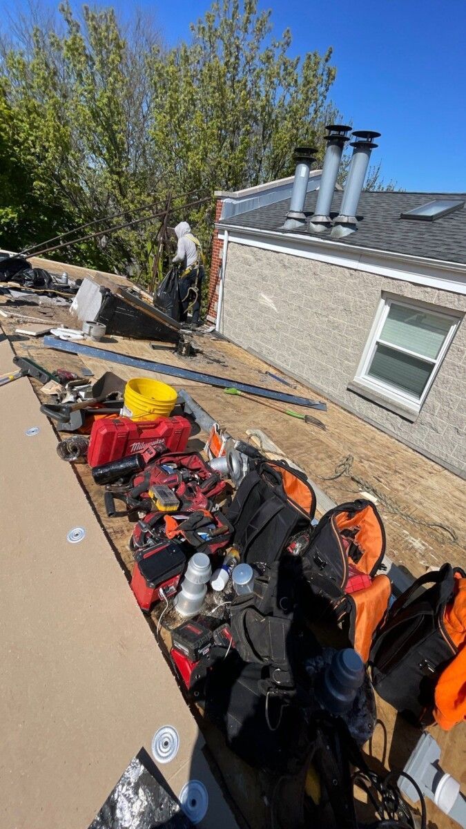 A bunch of tools are sitting on the roof of a house.