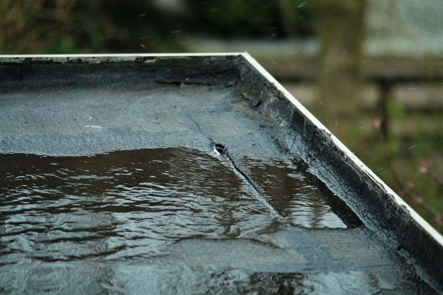 A close up of a roof with water coming out of it.