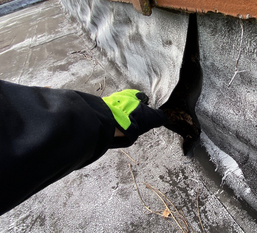 A person wearing a pair of neon green gloves is standing on a concrete surface.