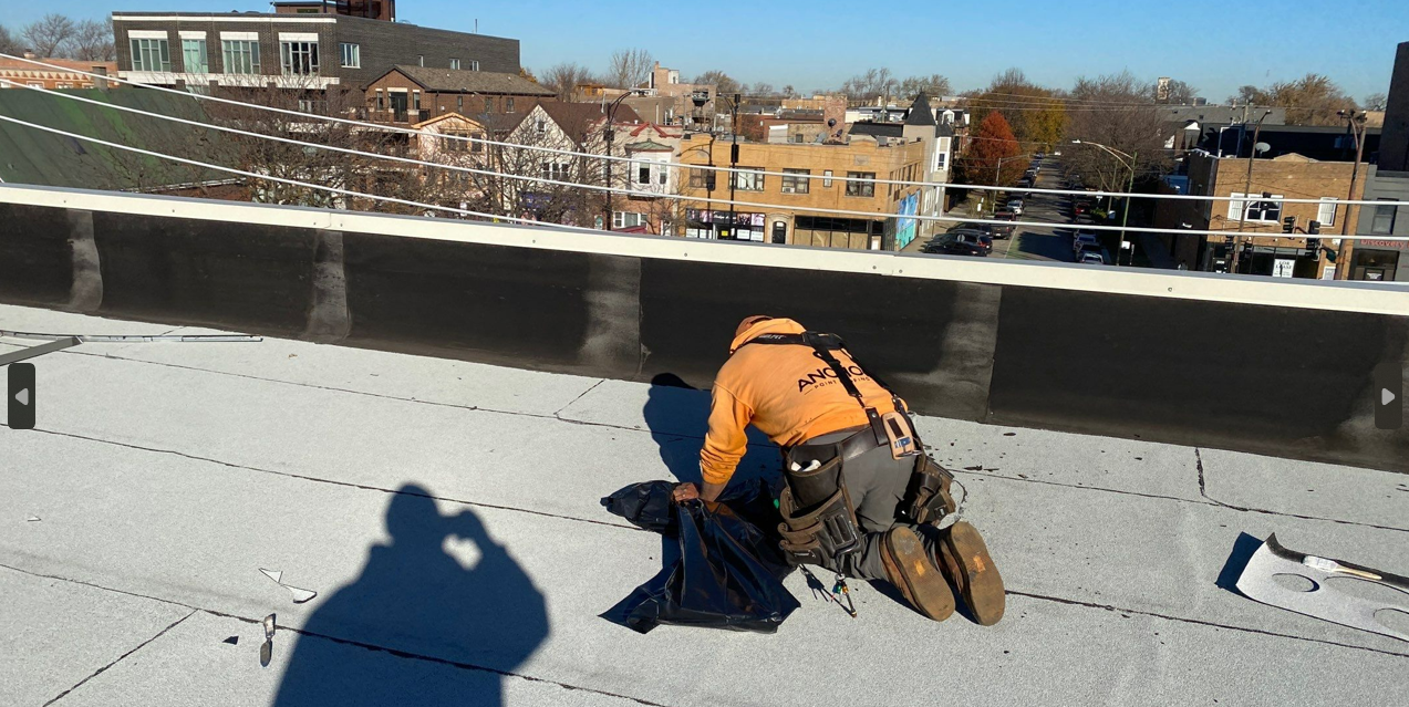 A man is working on a roof with a city in the background