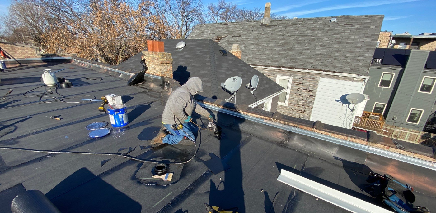 Two men are working on the roof of a building.