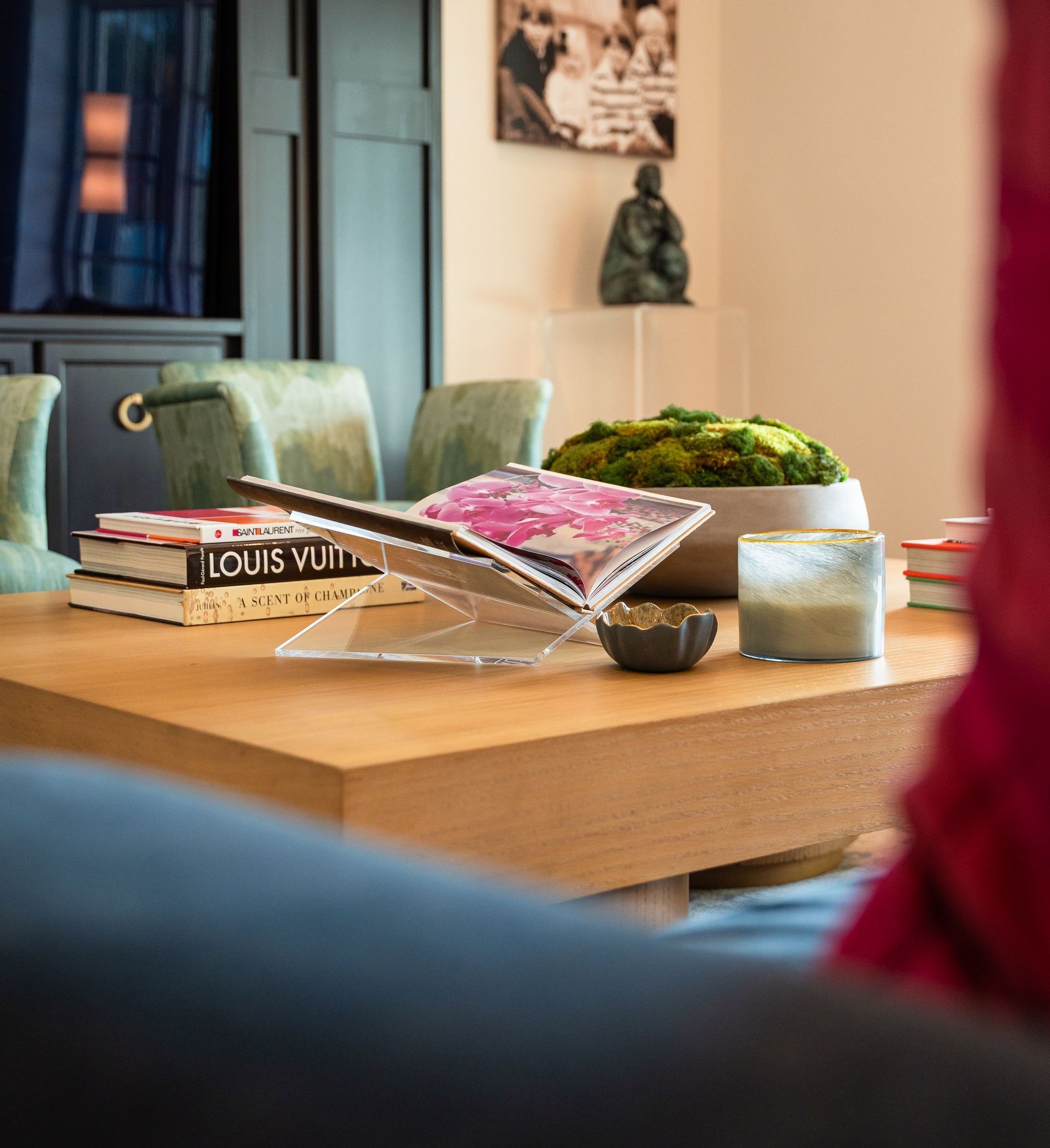 A wooden table with a magazine on it and a book titled louis vuitton