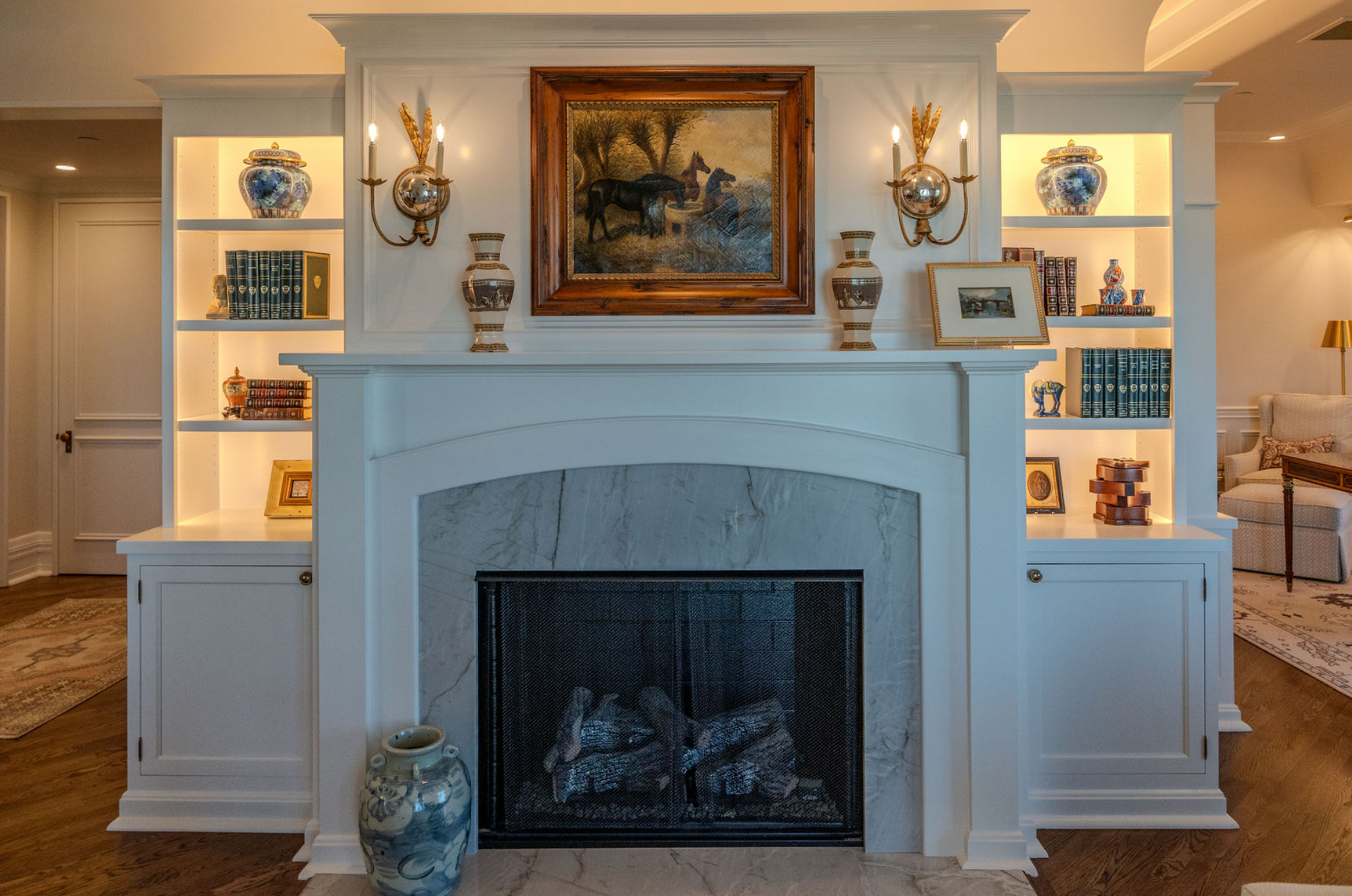 A living room with a fireplace and a painting on the wall.