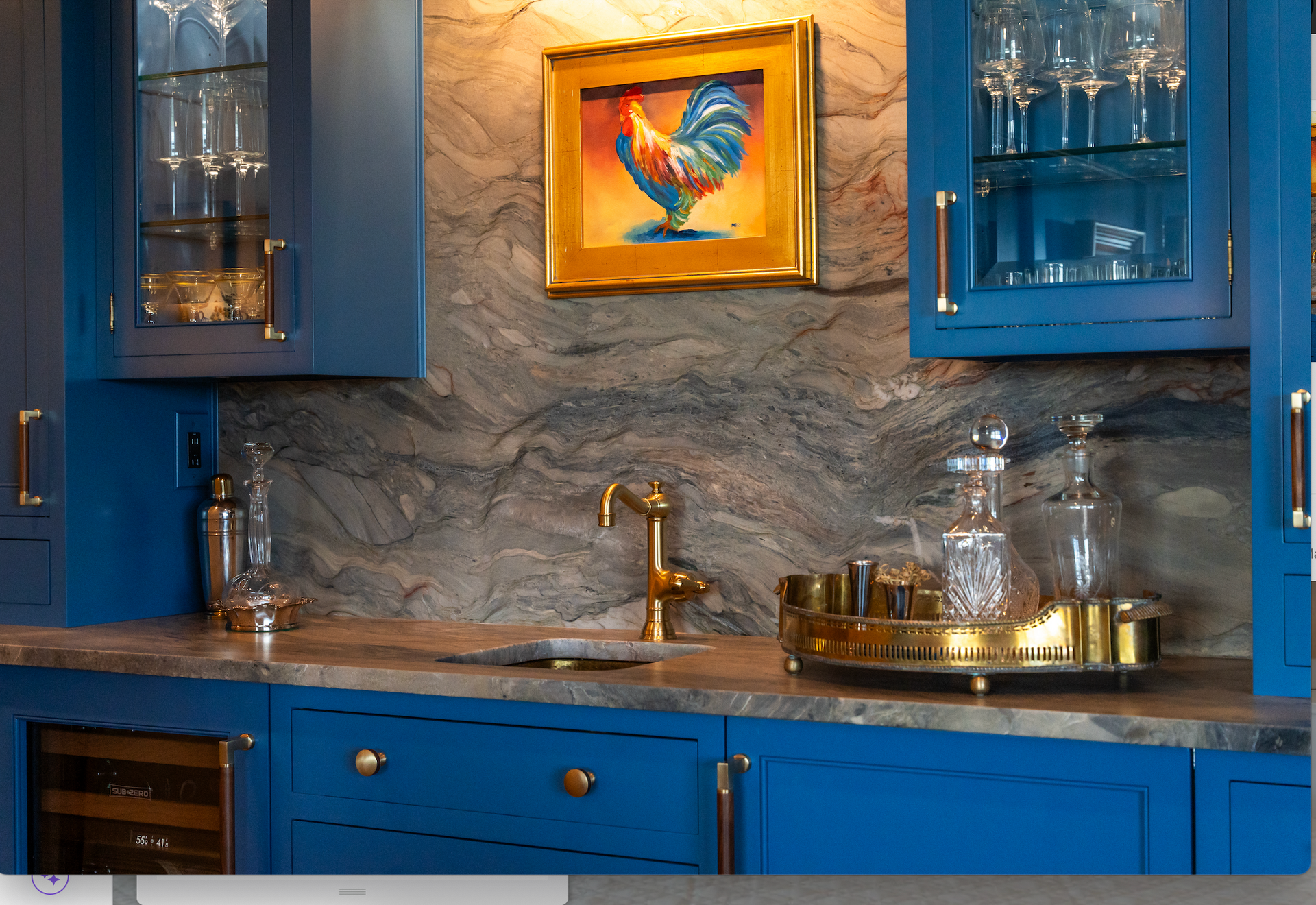 A kitchen with blue cabinets and a picture of a rooster on the wall