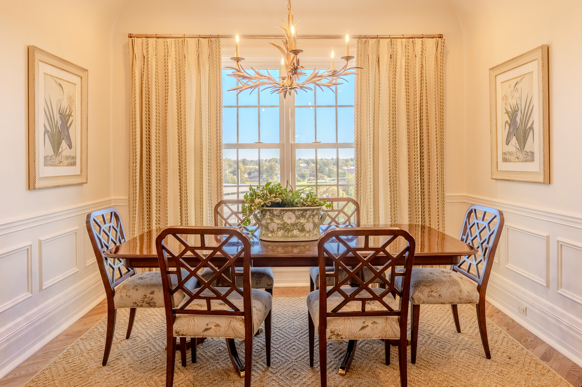 A dining room with a table and chairs and a chandelier.