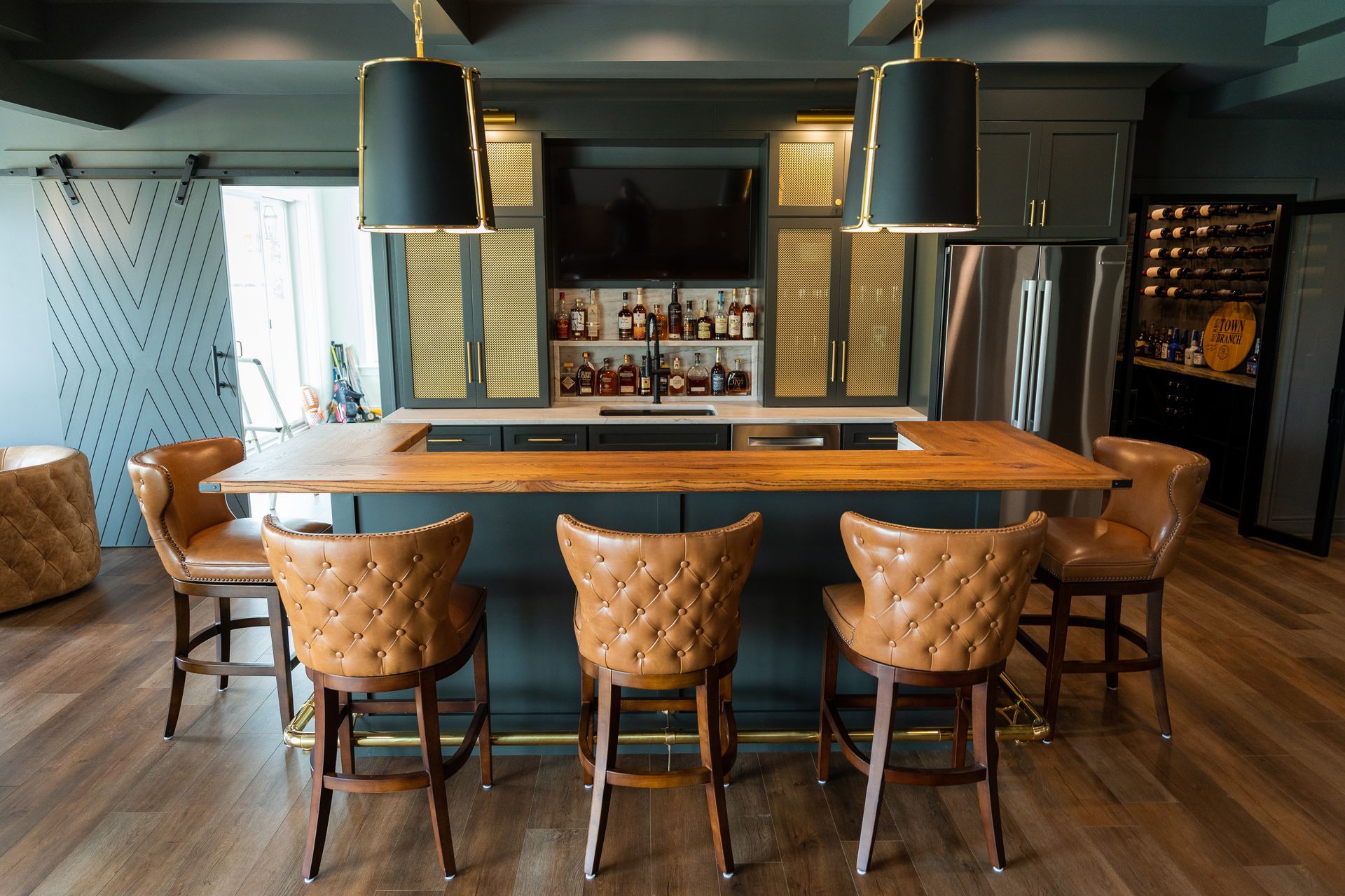A kitchen with a bar and chairs in it