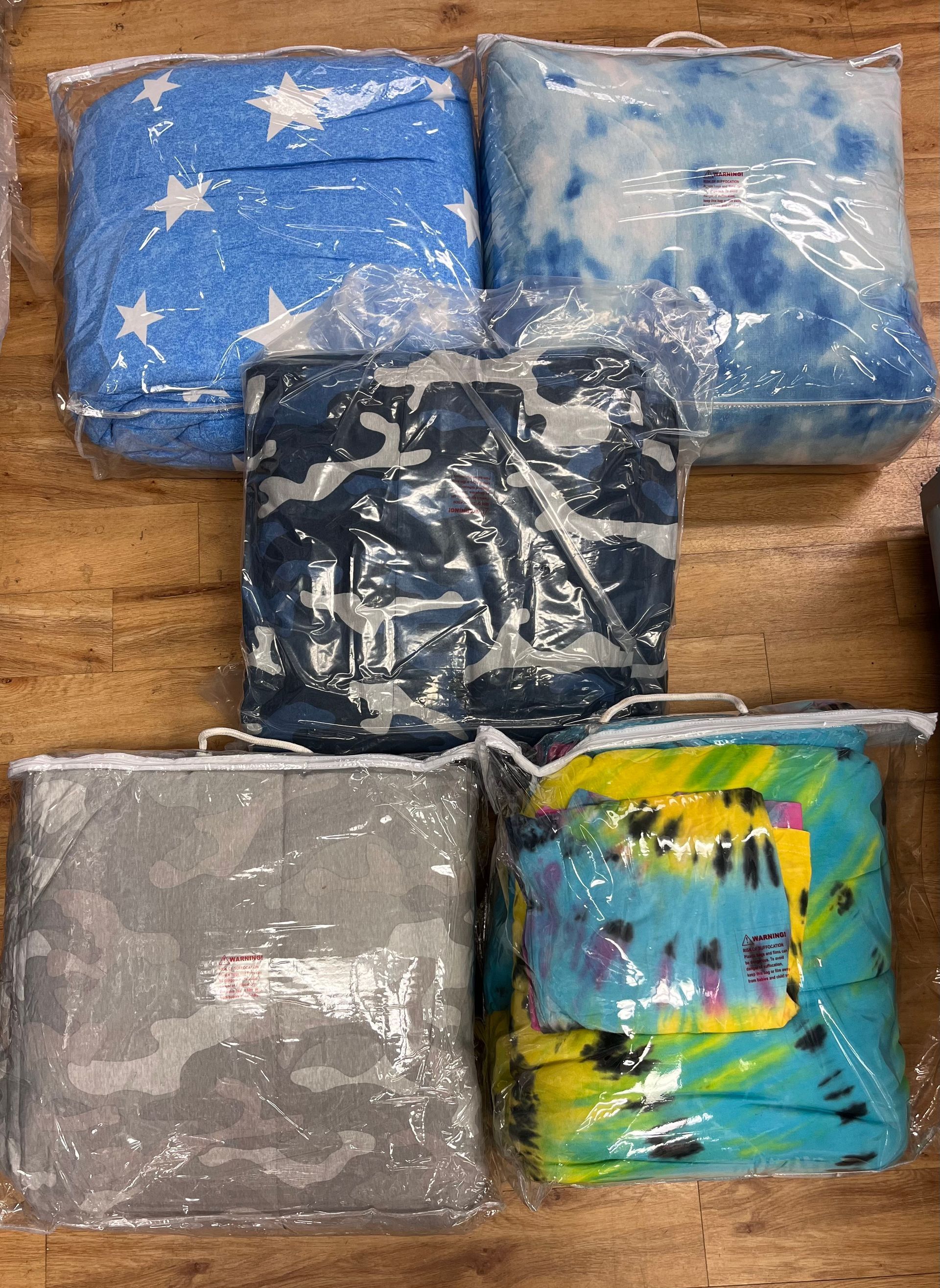 a bunch of blankets are sitting on top of each other on a wooden table .