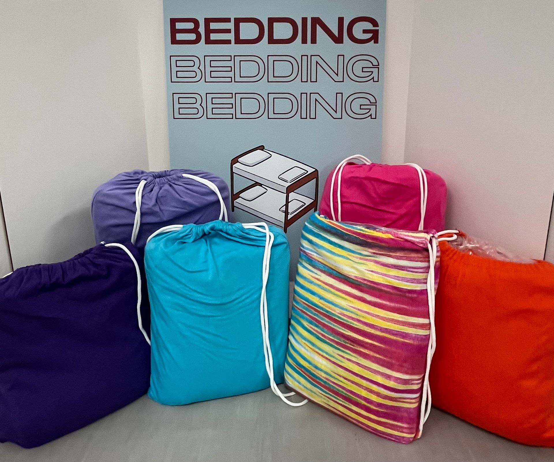 a bunch of bags are sitting in front of a sign that says bedding bedding bedding