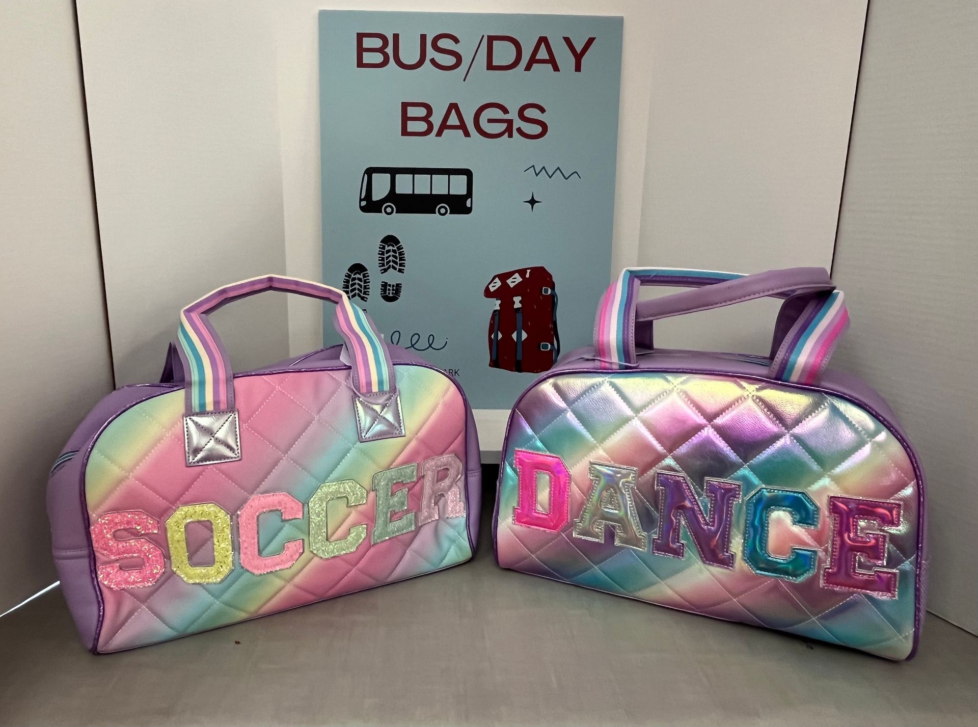 two bags are sitting on a table in front of a sign that says bus day bags .