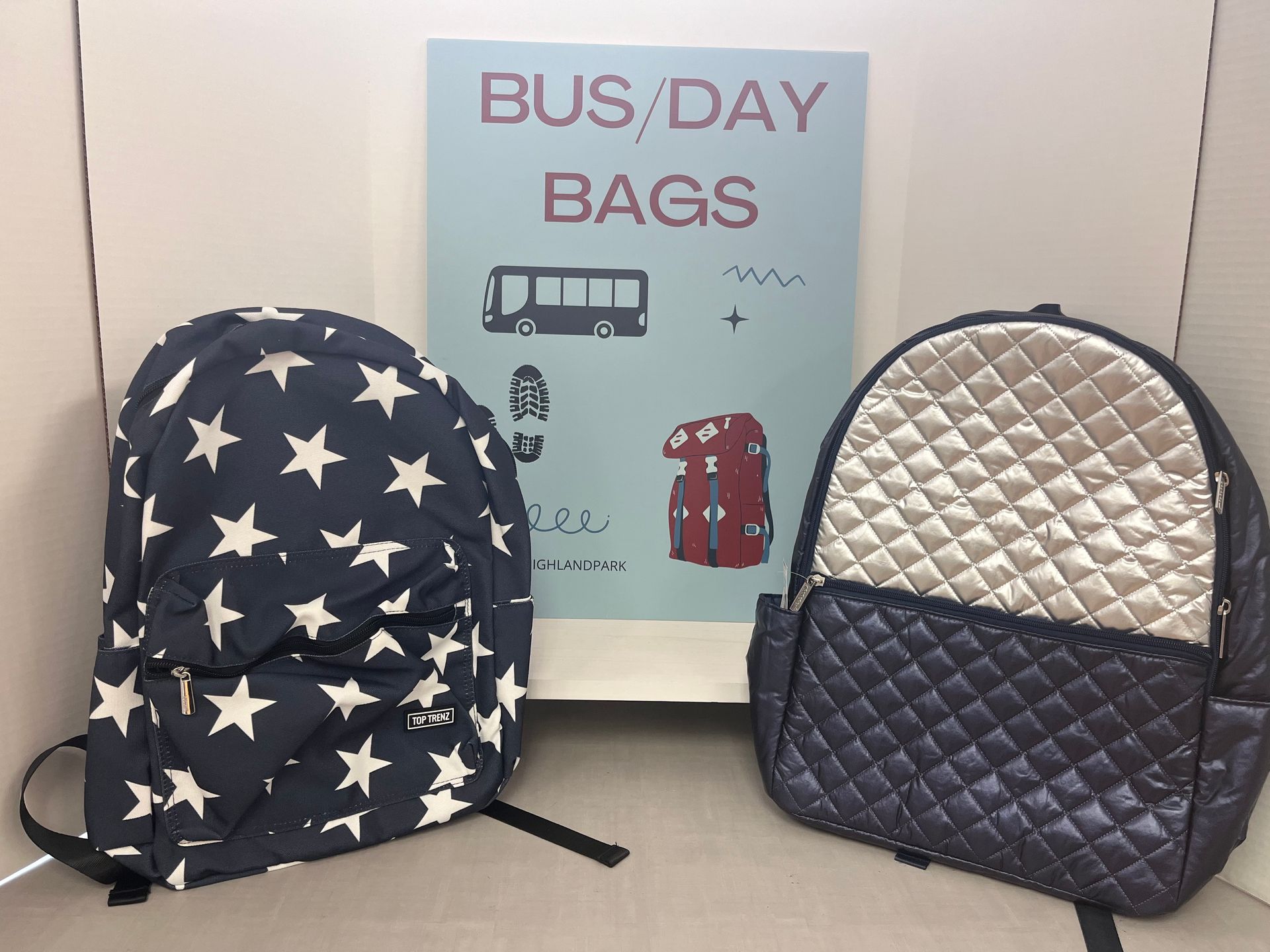two backpacks in front of a sign that says bus / day bags