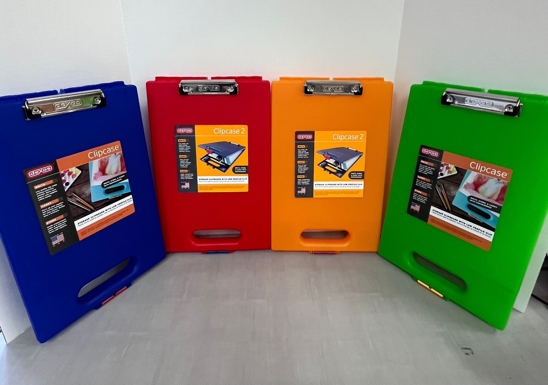 four clipboards in different colors are sitting on a table