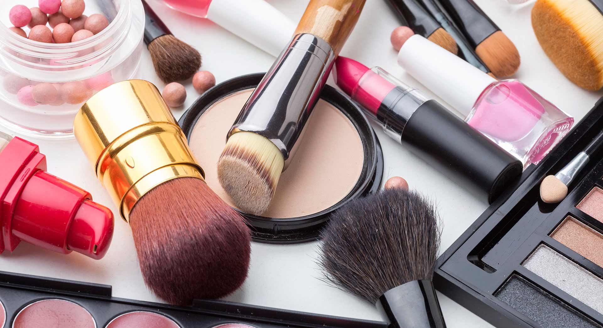 a group of makeup brushes sitting on top of a brown surface .