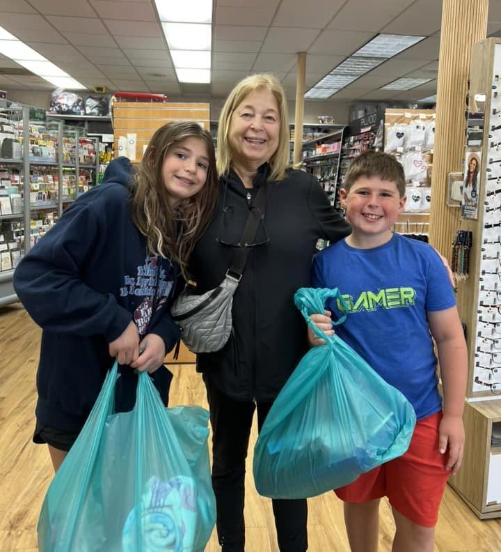 a boy wearing a gamer shirt is holding a bag